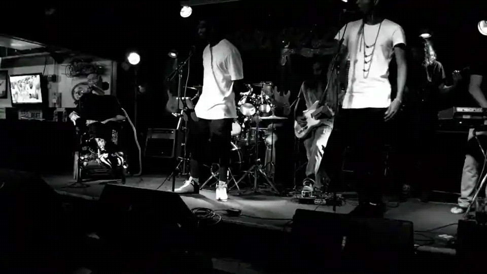 Band performing under stage lights, black and white